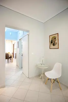 a white chair and a table in a room at Leo's home in Athens