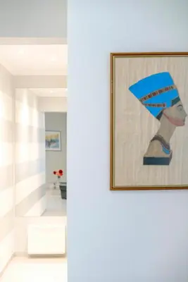 a painting of a woman in a blue hat on a wall at Leo's home in Athens