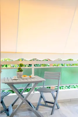 a picnic table and two chairs on a balcony at Leo's home in Athens