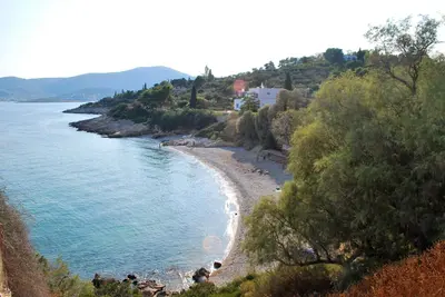 a beach with a group of people on the shore at The Mirador Boutique Villa with Scenic Sea View in Porto Rafti