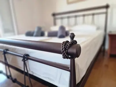 a metal bed with a rope attached to it at The Mirador Boutique Villa with Scenic Sea View in Porto Rafti