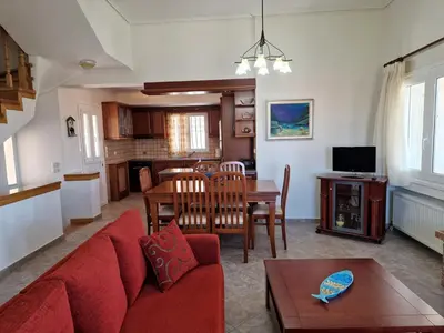 a living room with a red couch and a table at The Mirador Boutique Villa with Scenic Sea View in Porto Rafti