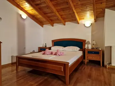 a bedroom with a bed with two pink pillows on it at The Mirador Boutique Villa with Scenic Sea View in Porto Rafti