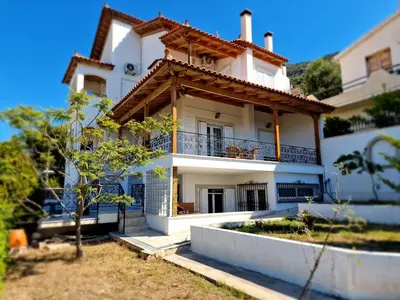 a white house with a balcony on the side of it at The Mirador Boutique Villa with Scenic Sea View in Porto Rafti