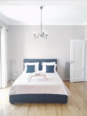 a bedroom with a large bed with a chandelier at The Athens Museum Penthouse 120sqm Lycabettus View in Athens