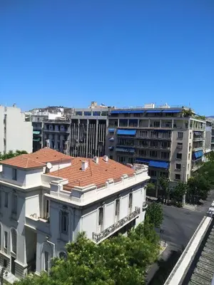 a white building with a red roof in front of a building at The Athens Museum Penthouse 120sqm Lycabettus View in Athens