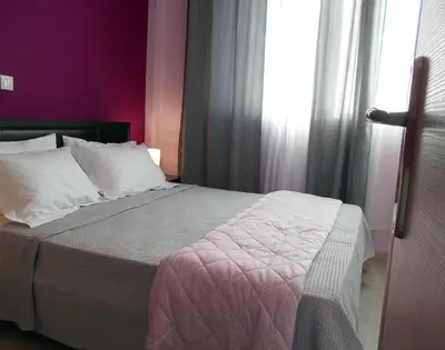 a bedroom with a bed with purple walls and a window at MiCasa SuCasa / Heart of Athens / Brand-New superlux in Athens