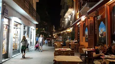 a group of people walking down a street at night at MiCasa SuCasa / Heart of Athens / Brand-New superlux in Athens