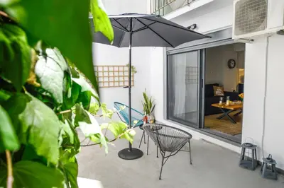 a patio with an umbrella and chairs and a table at Your Home Away from Home in Erectheium in Athens
