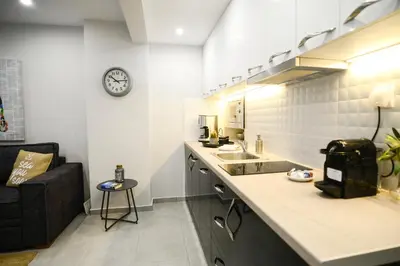 a kitchen with a counter and a clock on the wall at Your Home Away from Home in Erectheium in Athens