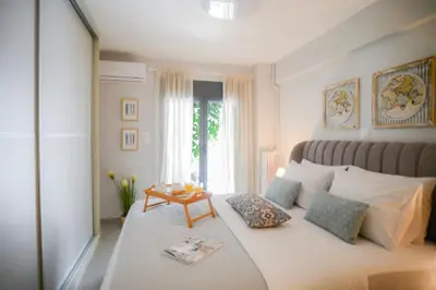 a bedroom with a bed with pillows and a table at Your Home Away from Home in Erectheium in Athens