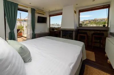 a bedroom with a large white bed and a balcony at Acropolis Eye Loft in Athens