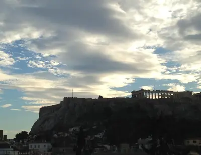 a building on top of a mountain under a cloudy sky at Acropolis Eye Loft in Athens
