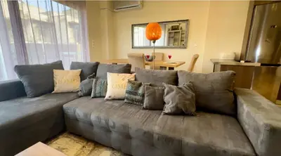 a gray couch with pillows in a living room at Acropolis Modern Apartments free parking,free pet hosting,Netflix in Athens