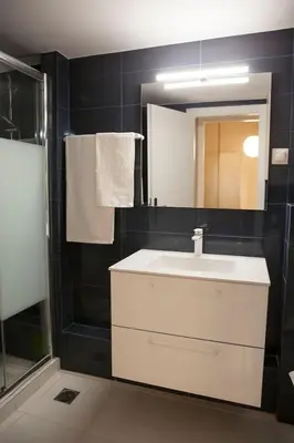 a bathroom with a white sink and a mirror at Chic & Comfortable Central Apart, close to National Archeological Museum! in Athens