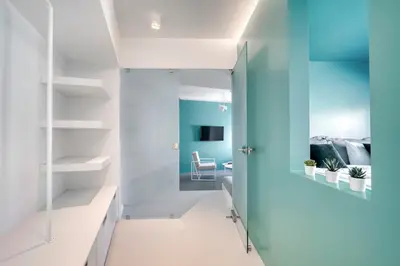a hallway with white shelves and a blue wall at Athens Color Cube in Athens
