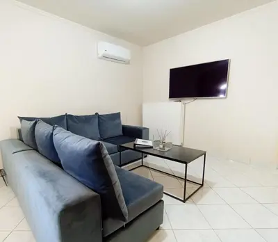 a living room with a blue couch and a table at Kalliopi's apartment in Athens