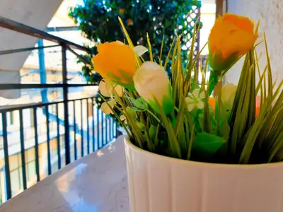 a white vase filled with yellow flowers on a table at Kalliopi's apartment in Athens