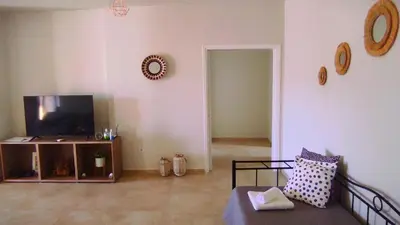 a living room with a tv and a couch at Comfortable Apartment Close to the Airport in Spáta