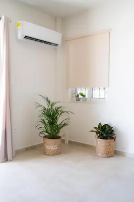 two plants in baskets in a room with a window at Comfortable Apartment Close to the Airport in Spáta