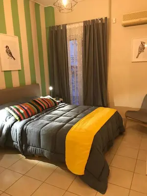 a bedroom with a bed with a yellow and grey comforter at Socrates path in Athens