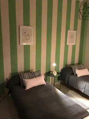 two beds in a room with green and white stripes at Socrates path in Athens