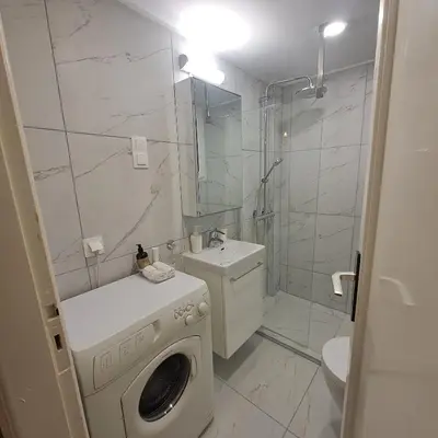 a bathroom with a washing machine and a shower at Socrates path in Athens