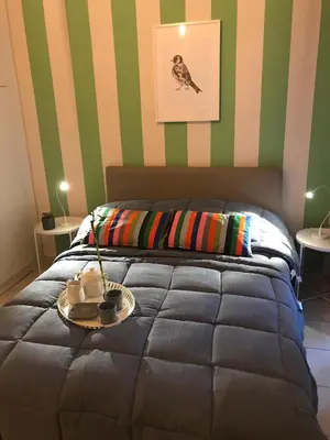 a bedroom with a bed with green and striped walls at Socrates path in Athens