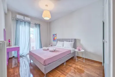 a bedroom with a large bed with a pink blanket at MUSE A Dreamy and Fresh New apartment in Athens
