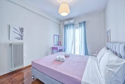 a bedroom with a bed with two towels on it at MUSE A Dreamy and Fresh New apartment in Athens
