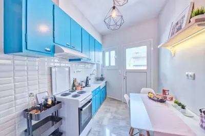 a kitchen with blue cabinets and a white stove top oven at MUSE A Dreamy and Fresh New apartment in Athens
