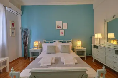 a bedroom with a large bed with a blue wall at Victoria 5star / 5BR BigApt / Sauna / 2min to metro in Athens