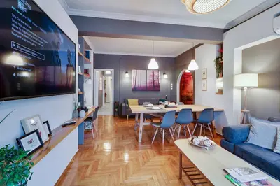 a living room with a blue couch and a table at Victoria 5star / 5BR BigApt / Sauna / 2min to metro in Athens