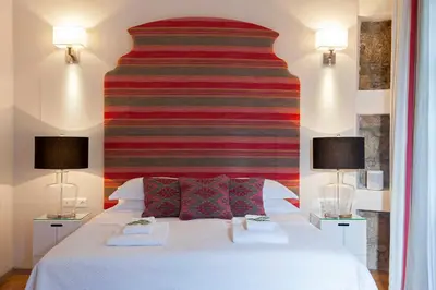 a bedroom with a large white bed with two lamps at Acropolis TownHouseCo Suites in Athens