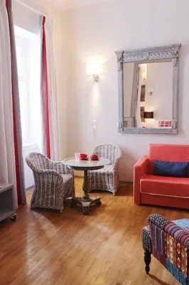 a living room with a red couch and a table at Acropolis TownHouseCo Suites in Athens