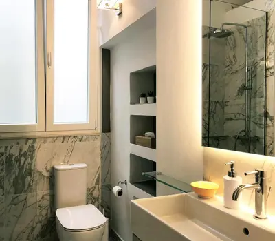 a bathroom with a toilet and a sink at Acropolis TownHouseCo Suites in Athens
