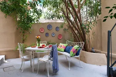 a patio with a table and chairs and a tree at Acropolis TownHouseCo Suites in Athens