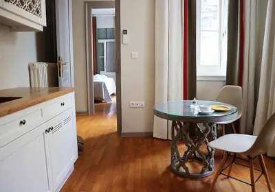 a kitchen with a table and a table and chairs at Acropolis TownHouseCo Suites in Athens