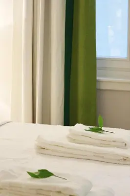 two towels sitting on top of a white bed at Acropolis TownHouseCo Suites in Athens
