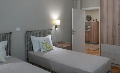 a bedroom with two beds and a hallway at Absolute Athens ΙΧ in Athens