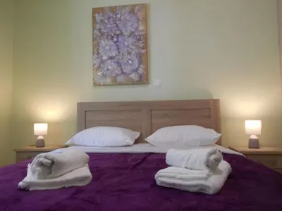 a bed with two towels on it with two lamps at Koukaki-comfy with a balcony apt. in Athens