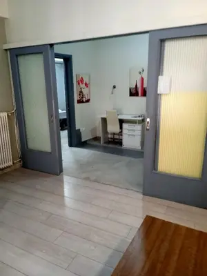a room with two doors and a table with a desk at Koukaki-comfy with a balcony apt. in Athens