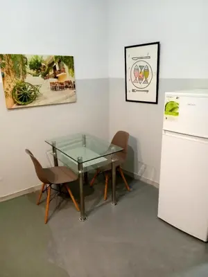 a dining room with a glass table and a refrigerator at Koukaki-comfy with a balcony apt. in Athens