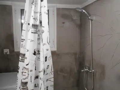 a bathroom with a shower with a shower curtain with a shower at Koukaki-comfy with a balcony apt. in Athens