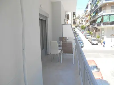 a balcony with a table and chairs on a city street at Koukaki-comfy with a balcony apt. in Athens