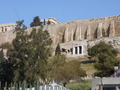 a building with columns on the side of a hill at Koukaki-comfy with a balcony apt. in Athens