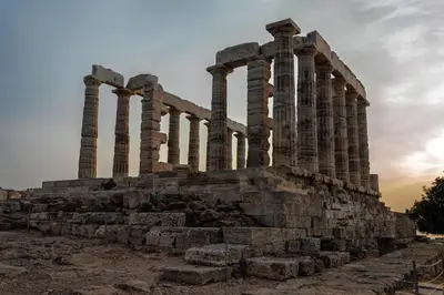 an ancient temple with columns at sunset at Amazing Seafront Apartment Athens Riviera in Athens