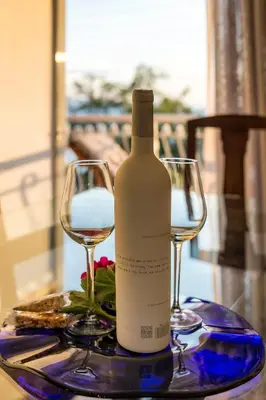 a bottle of wine and two glasses on a table at Amazing Seafront Apartment Athens Riviera in Athens