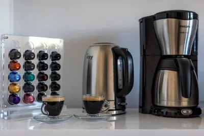 a coffee maker and two cups of coffee on a counter at Amazing Seafront Apartment Athens Riviera in Athens