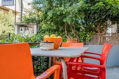 a table with orange chairs and a bowl of fruit on it at ANAFIS COMFORT in Athens